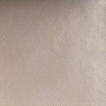 Rugiano leather swatch, muted taupe color, fine grain texture, matte finish, neutral background, consistent even surface, warm gray tones.
